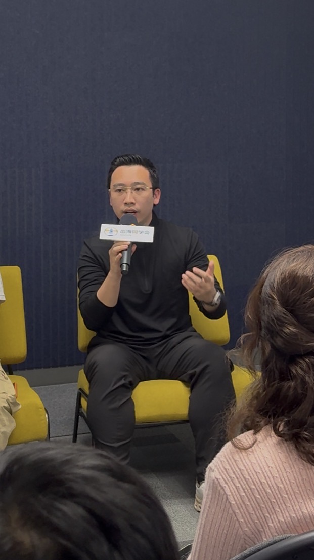 Joven Lee speaking on a panel with a microphone